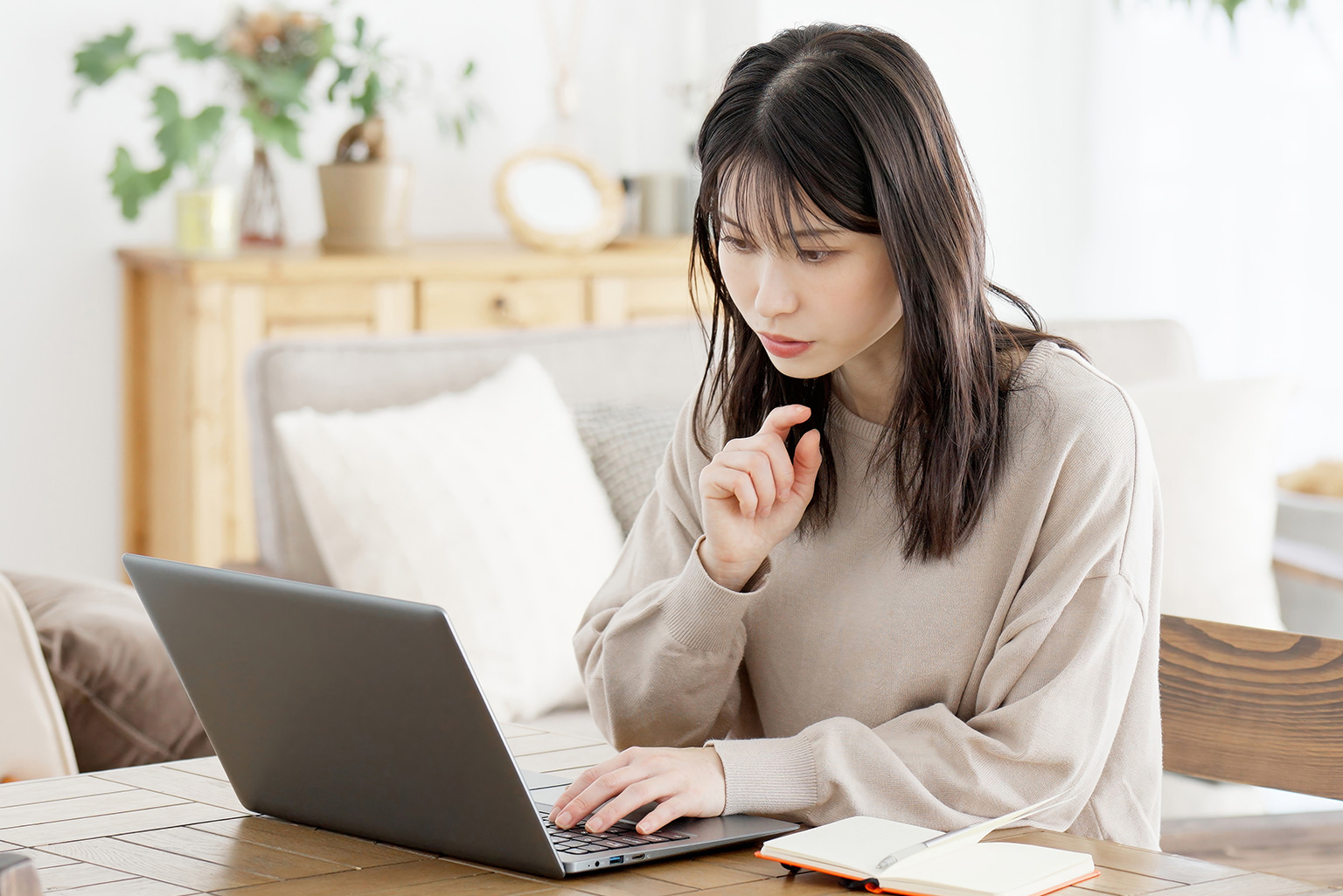 自宅でパソコンを使い、真剣な表情で勉強する女性