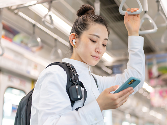 電車でスマホを見る女性